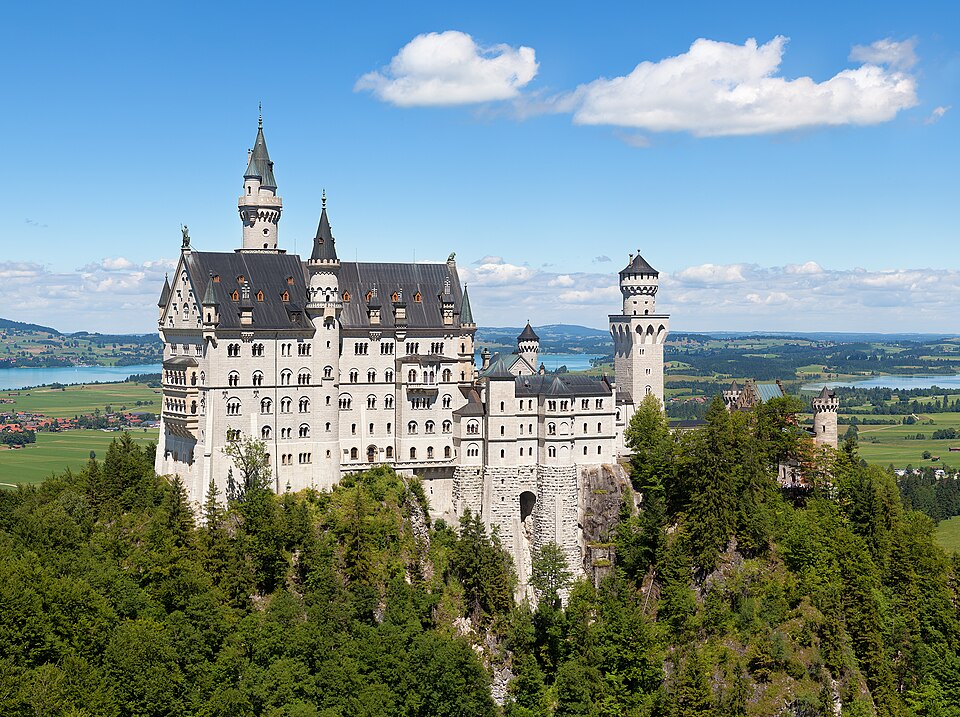 Neuschwanstein Castle on a wooded ridge above the Alpine foreland.
